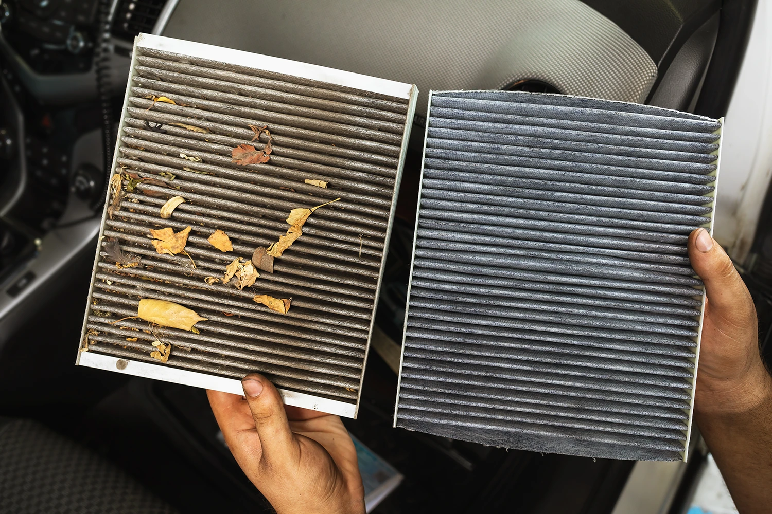 Verschmutzter Pollenfilter wird beim Reinigen der Klimaanlage aus dem Filterkasten des Autos gezogen