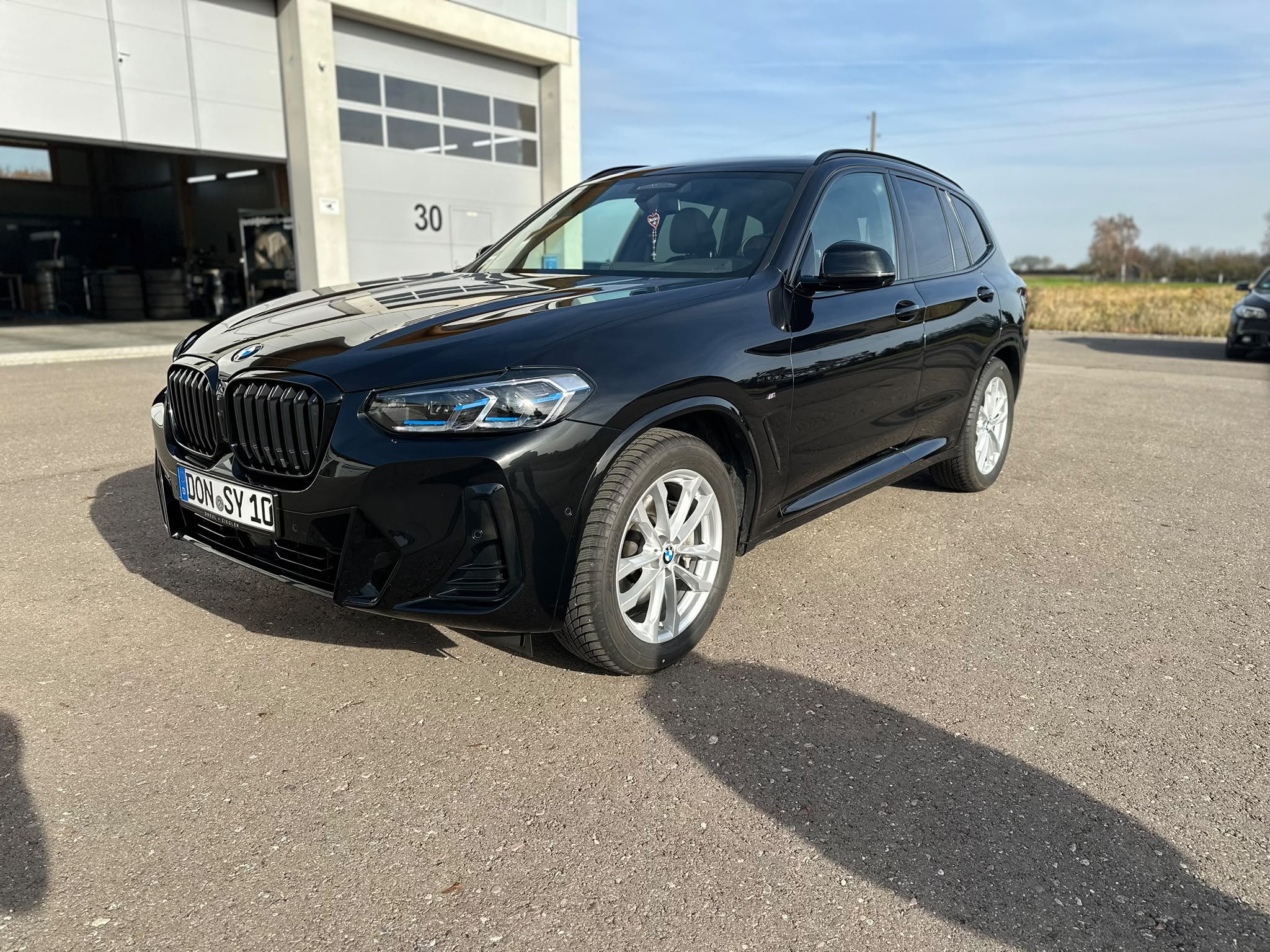 Schwarzer BMW X3 xDrive30d von schräg vorn nach der Lackaufbereitung bei Autopflege Meilinger in Höchstädt