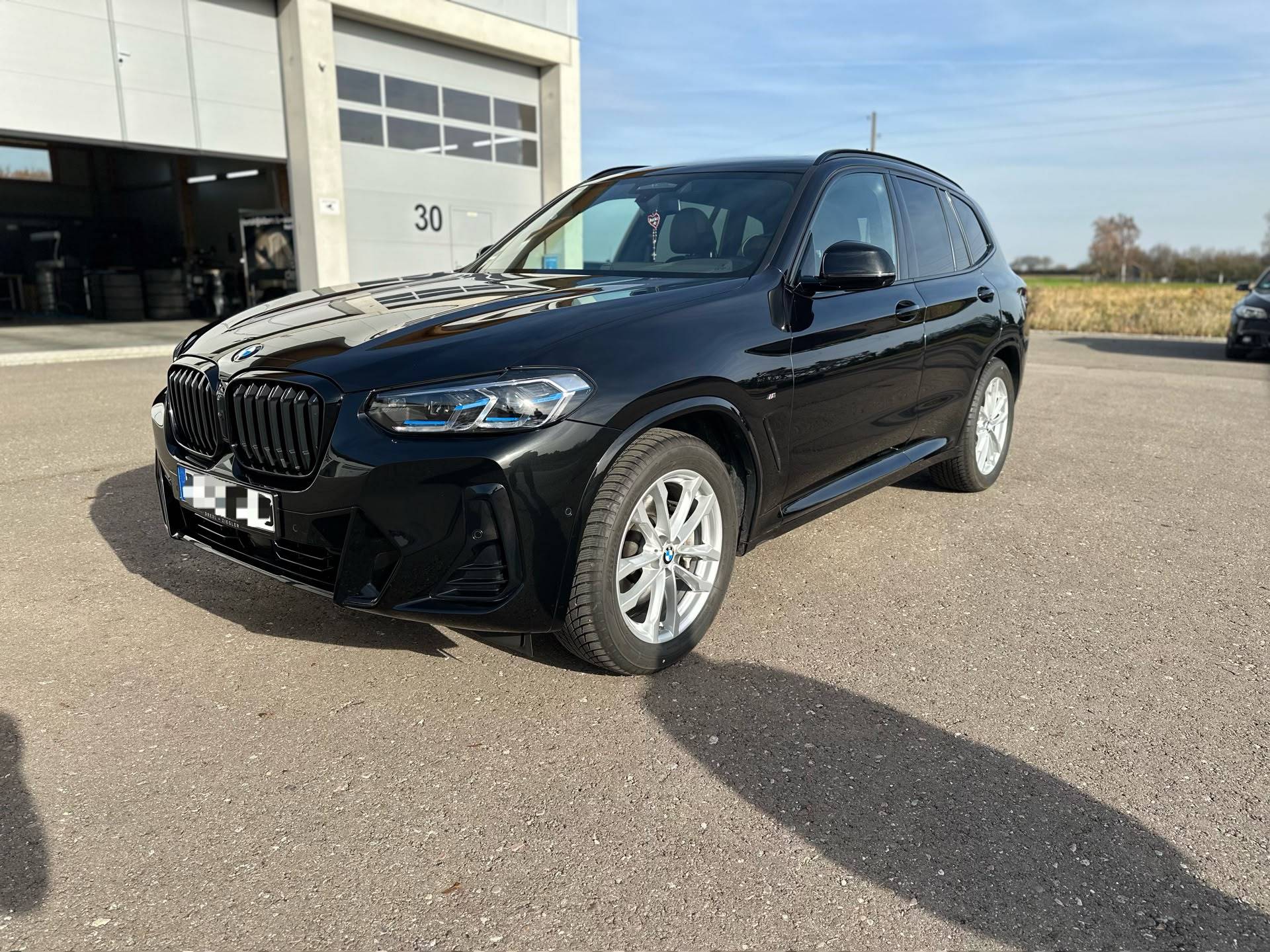 Schwarzer BMW X3 xDrive30d von schräg vorn nach der Lackaufbereitung bei Autopflege Meilinger in Höchstädt