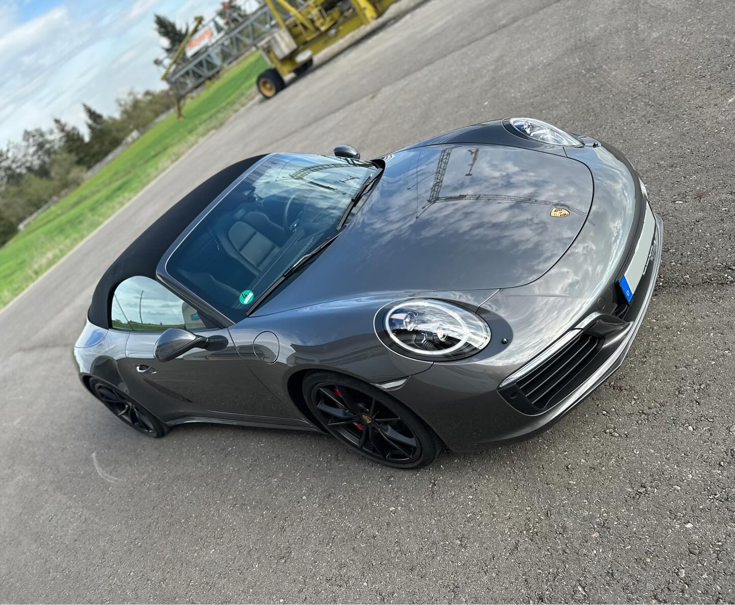 Grauer Porsche 911 Carrera 4S Cabrio mit geschlossenem Verdeck von schräg vorn nach Lackkorrektur und Keramikversiegelung bei Autopflege Meilinger