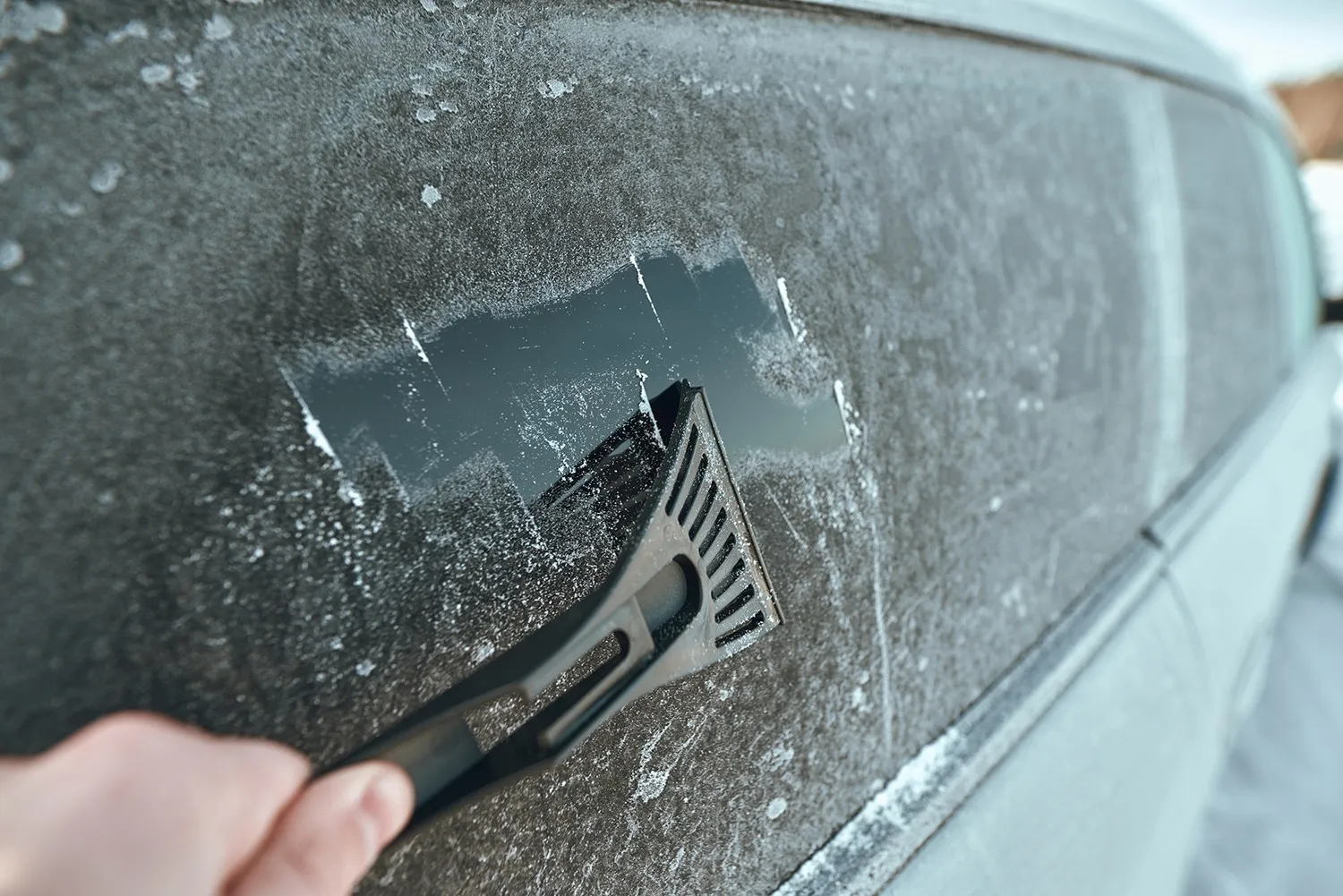 Scheibe enteisen falsch: Mit dem Eiskratzer wird nur ein kleines Guckloch in die vereiste Seitenscheibe gekratzt